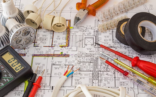Werkzeuge und elektronische Gegenstände auf Bauplänen