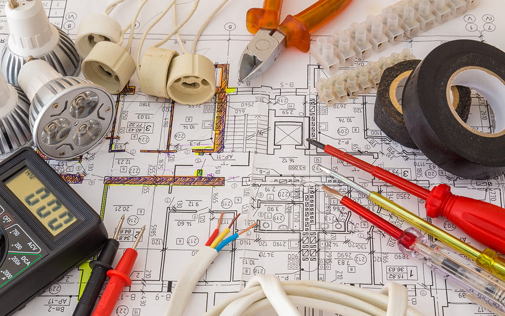 Werkzeuge und elektronische Gegenstände auf Bauplänen